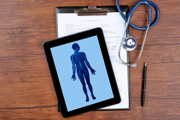Imagem médica na tela do tablet e estetoscópio em fundo de madeira — Fotografia de Stock