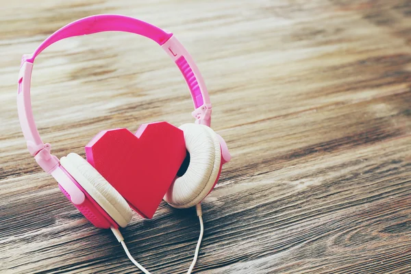 Pink headphones with rosy heart — Stock Photo, Image
