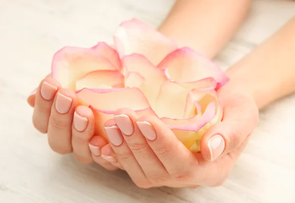 Mani di donna con bei petali di rosa — Foto Stock