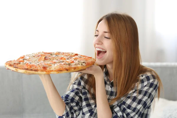 Счастливая молодая женщина держит пиццу — стоковое фото