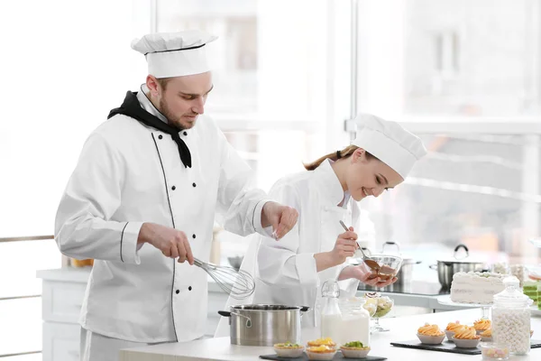 Mannelijke en vrouwelijke chef-koks werken — Stockfoto