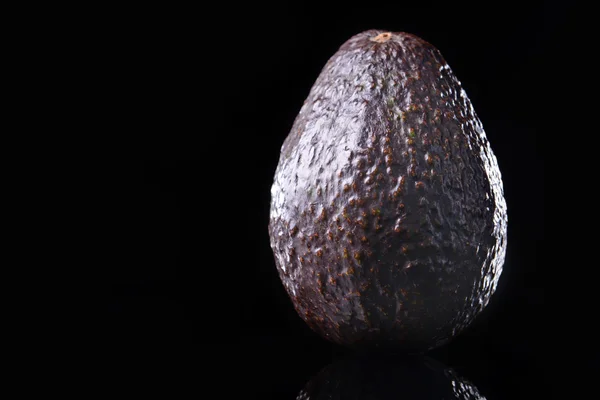 Fresh avocado on black — Stock Photo, Image