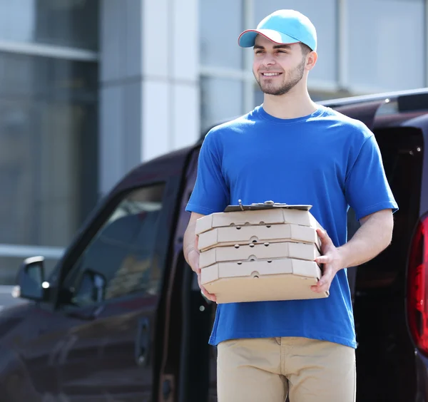 Muž hospodářství pizza mimo — Stock fotografie