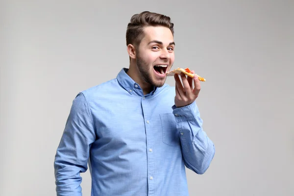 Молодой красивый мужчина с пиццей — стоковое фото