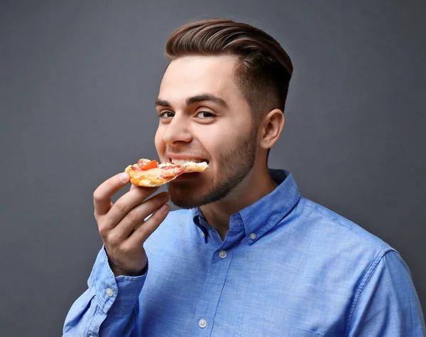 Ung vacker man äta pizza — Stockfoto