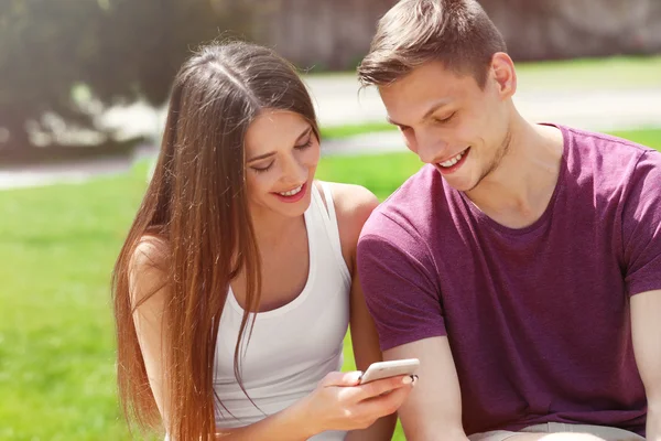 Jovem Casal Amoroso Usando Telefone Celular Parque Primavera — Fotografia de Stock