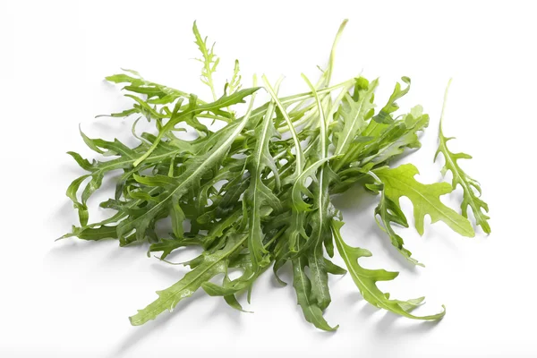 Folhas de arugula frescas no fundo branco — Fotografia de Stock