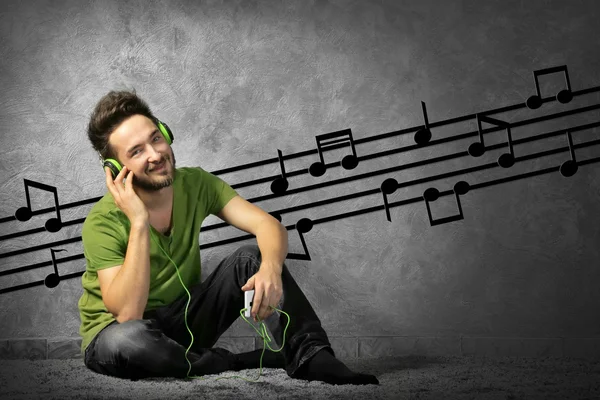 Joven Con Auriculares Escuchando Música Sentada Sobre Fondo Gris Pared — Foto de Stock