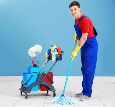 Fırçalar ve deterjanlar gri arka plan üzerinde olan adam