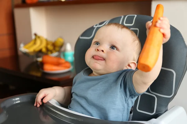 Baby holding carrot — Stock Photo, Image