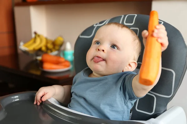 Baby holding carrot — Stock Photo, Image