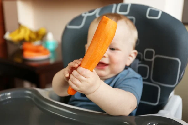 Baby holding carrot — Stock Photo, Image