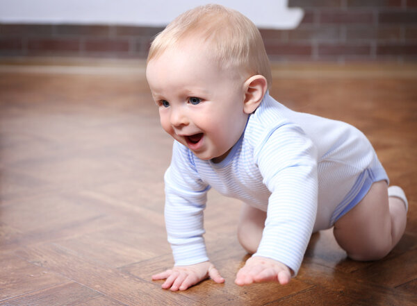 Crawling baby on the wooden floor  