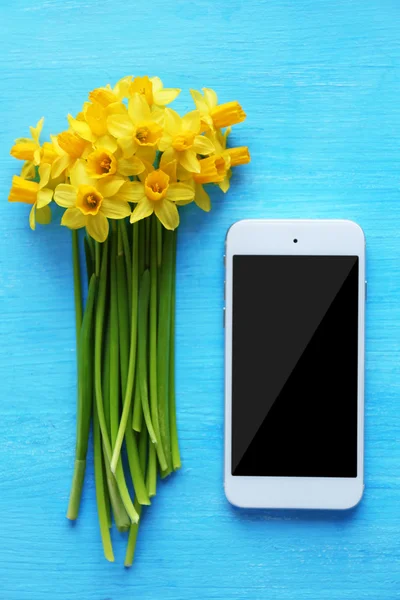 Narcisos amarillos y smartphone —  Fotos de Stock