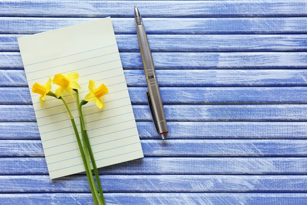 Yellow daffodils and notebook — Stock Photo, Image