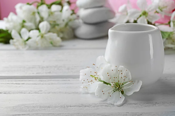 Olja med vita blommor på bord — Stockfoto