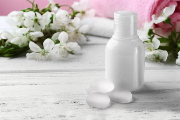 Cosmetic in bottle oand flowers — Stock Photo, Image