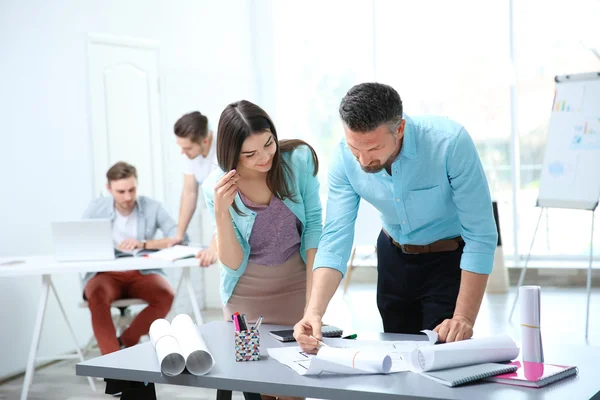 Gruppen Unga Ingenjörer Som Arbetar Med Ritningar Vid Bord Inomhus — Stockfoto