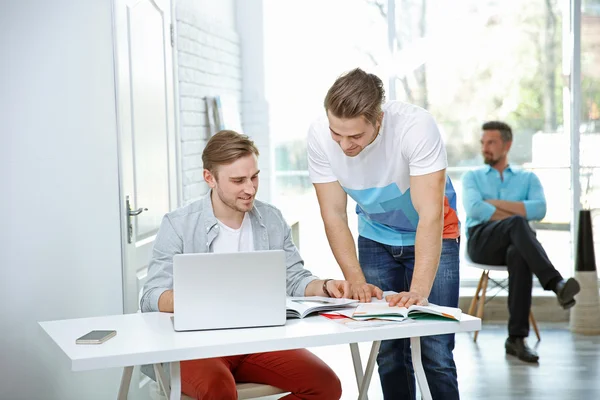 Gruppen Unga Ingenjörer Som Arbetar Med Ritningar Vid Bord Inomhus — Stockfoto