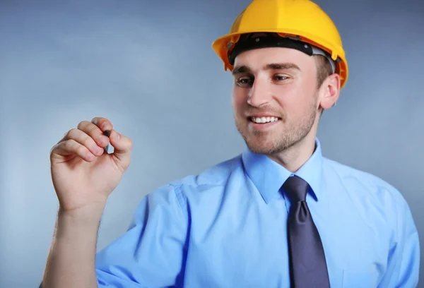 Mann im Helm hält Bleistift in der Hand — Stockfoto