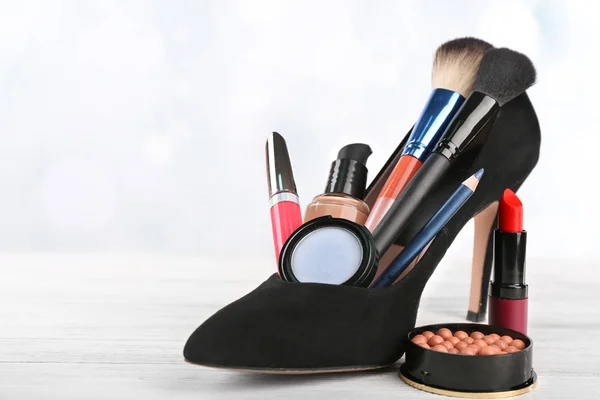 Makeup set with black woman's shoe — Stock Photo, Image