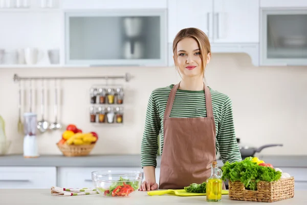 Junge Frau bereitet Gemüsesalat zu — Stockfoto