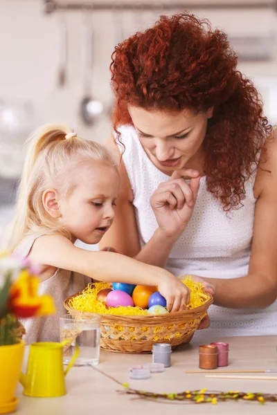 Мать и дочь украшают пасхальные яйца — стоковое фото