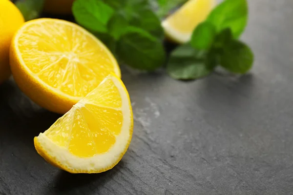 Plakjes verse citroen met groene bladeren — Stockfoto