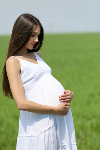 Gravid kvinna avkopplande i fältet — Stockfoto