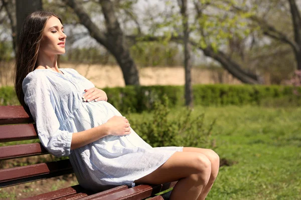 Donna incinta seduta nel parco — Foto Stock