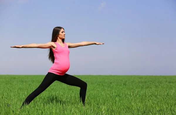 Zwangere vrouw praktizerende yoga vormen — Stockfoto