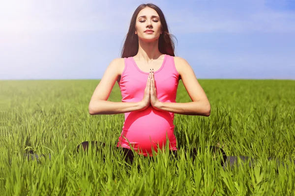 Mujer embarazada practicando yoga pose — Foto de Stock