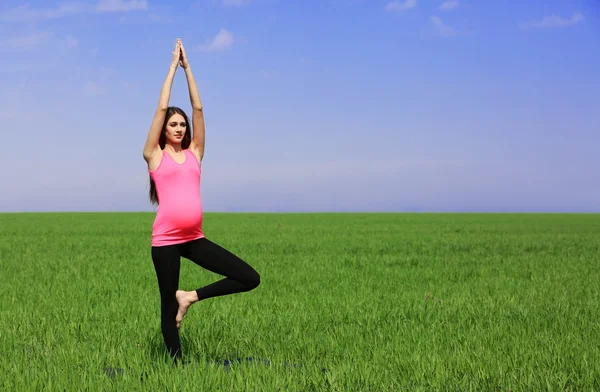 Mulher grávida praticando pose de ioga — Fotografia de Stock