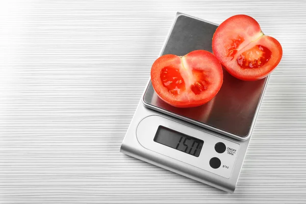 Tomatoes with digital kitchen scales — Stock Photo, Image