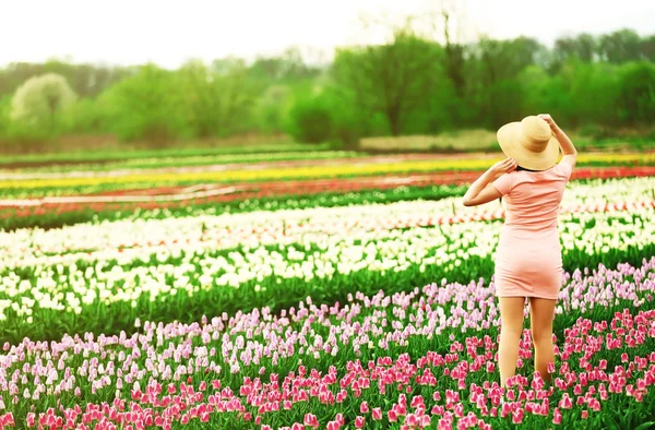 Frau auf blühendem Tulpenfeld — Stockfoto