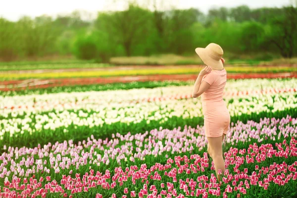 Vrouw op bloeiende gebied van tulpen — Stockfoto