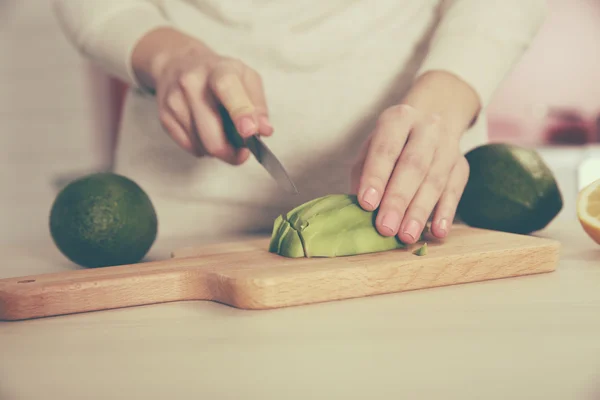 Frau schneidet frische Avocado — Stockfoto