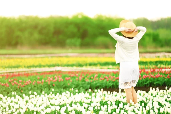 Frau auf blühendem Tulpenfeld — Stockfoto