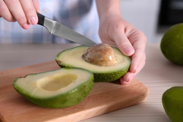 Woman cutting fresh avocado — Stock Photo, Image