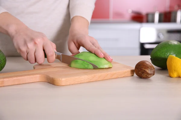 Frau schneidet frische Avocado — Stockfoto