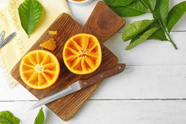 Reducida a la mitad jugosa naranja sobre tabla de madera —  Fotos de Stock