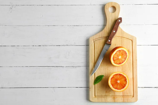 Reducido a la mitad jugosa naranja siciliana sobre tabla de madera —  Fotos de Stock