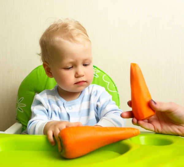 Cute baby playing with fresh carrot — Stock Photo, Image