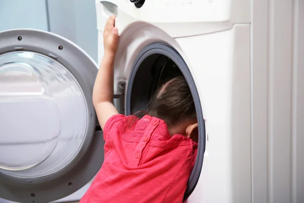 Girl playing with washing machine — Stock Photo, Image