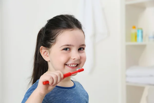Sonriente niña cepillándose los dientes — Foto de Stock