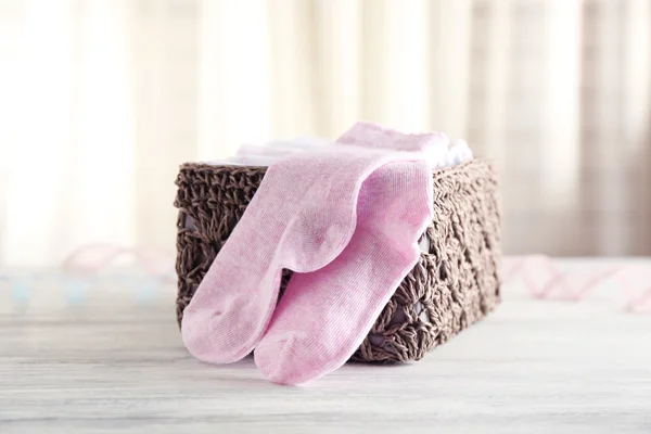 Baby socks in wicker box — Stock Photo, Image