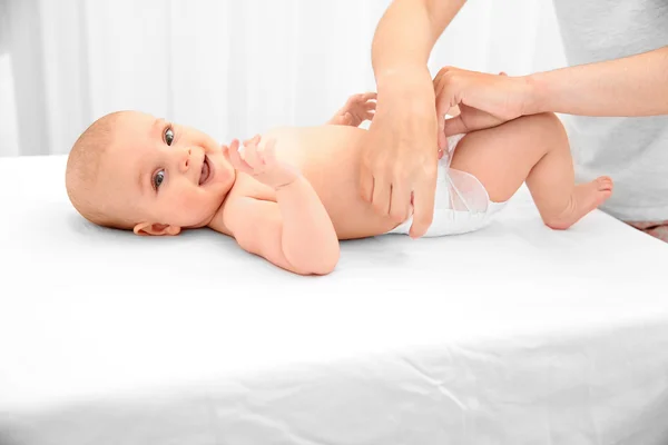 Madre cambiando pañal a pequeño bebé —  Fotos de Stock