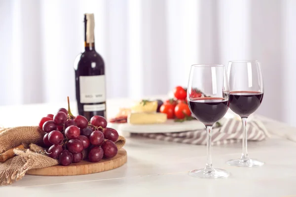 Glasses of red wine with food — Stock Photo, Image