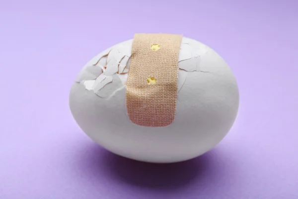 Cracked egg with plaster — Stock Photo, Image