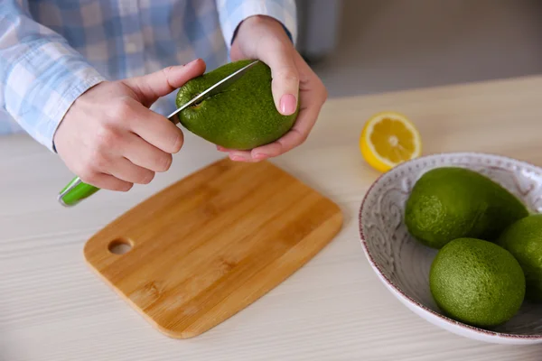 Mujer cortando aguacate fresco — Foto de Stock